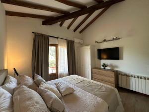 a bedroom with a large bed and a television at Casa Cayé Solar del Plata in Vistalba