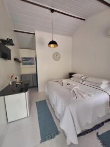 Pousada PraiAmar في سانت أندري: غرفة نوم بيضاء مع سرير كبير وطاولة