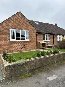 a brick house with a garden in front of it at Immaculate 4-Bed Cottage in Knaresborough in Knaresborough