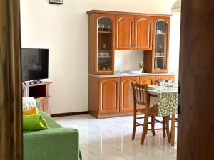 a kitchen with wooden cabinets and a table with chairs at Tuscany Panoramic View - Relax in Val D'Orcia in Seggiano