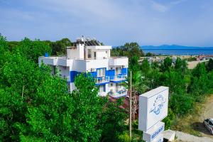 グムルドゥルにあるGumuldur Deniz Kızı Green Gardenの青い木の大きな白い建物
