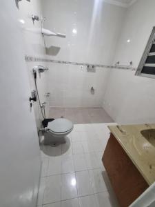 bagno bianco con servizi igienici e lavandino di Villa Fátima Hostel GRU a Guarulhos