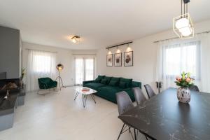 a living room with a green couch and a table at Holiday Home Kiara in Brtonigla