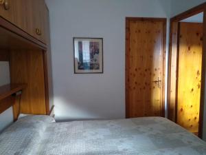 - une chambre avec un lit et une porte en bois dans l'établissement Scopello Vacanze, à Scopello