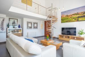 een woonkamer met witte meubels en een wenteltrap bij Sa Riba in Muro