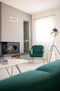 a living room with a green chair and a fireplace at Holiday Home Kiara in Brtonigla