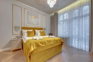 1 dormitorio con 1 cama grande con manta amarilla en Sopot Pod Orłem Monte Cassino by Downtown Apartments en Sopot