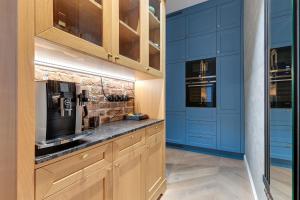 cocina con armarios azules y encimera en Sopot Pod Orłem Monte Cassino by Downtown Apartments en Sopot