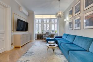 a living room with a blue couch and a tv at Sopot Pod Orłem Monte Cassino by Downtown Apartments in Sopot