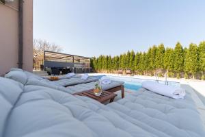 a row of lounge chairs next to a swimming pool at Holiday Home Kiara in Brtonigla