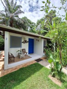 ein Haus mit einer blauen Tür und einem Hof in der Unterkunft Pousada PraiAmar in Santo André