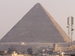 einen Blick auf die Pyramiden von Gizeh und eine Stadt in der Unterkunft Sneferu Pyramids inn - Full Pyramids View in Kairo