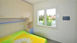 a small room with a bed and a window at Terraced house with private garden in Bibione