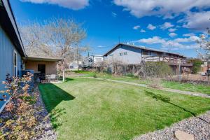 a backyard with a yard of grass and a house at La Verkin Home with Yard, Covered Patio and Grill in La Verkin