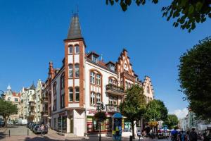 a tall brick building with a tower on a street at Sopot Pod Orłem Monte Cassino by Downtown Apartments in Sopot