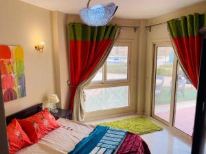 a bedroom with a bed and a large window at Pyramids Porto El Sokhna Familis Only in Ain Sokhna