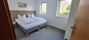 a bedroom with a bed with white sheets and pillows at Komfortabele Ferienwohnung in ruhiger Lage in Sassnitz