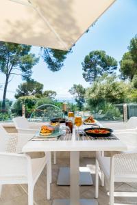 einen weißen Tisch mit Essen auf der Terrasse in der Unterkunft Mar Hotels Alcanada in Port d'Alcúdia