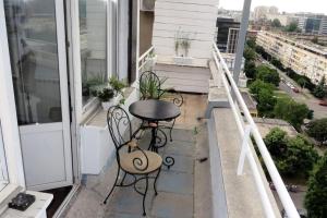 un balcón con 2 sillas y una mesa en el balcón en Rooftop New Belgrade Apartment, en Belgrado