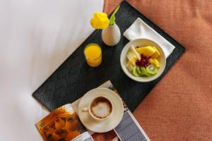 a tray with a cup of coffee and a plate of food at Jardín Milenio in Elche