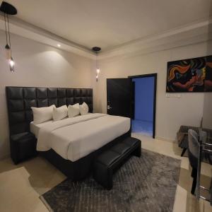 1 dormitorio con 1 cama grande y puerta azul en melbrookeparkhotel en Lagos