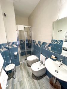y baño con 2 lavabos, aseo y ducha. en Hotel Riviera, en Porto San Giorgio