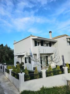 una casa blanca con una valla delante en Villa Theo Corfu, en Ágios Ioánnis