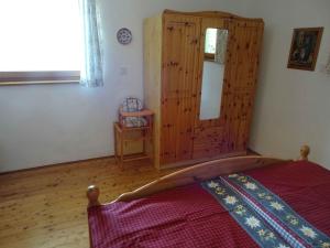 een slaapkamer met een bed en een houten kast bij Chalet in Diex near Klopeiner See with sauna in Diex