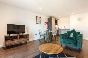 a living room with a tv and a couch and a table at Modern 2 bed 2 bath apartment in the heart of York in York