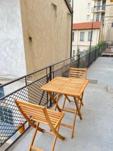 2 tavoli e sedie in legno su un balcone di Bocconi Navigli -La casa di Zoe with free Netflix and WiFi a Milano