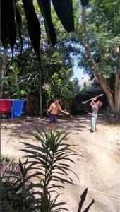 two people playing a game of baseball in a park at Moov Inn Garden Hostel in Ko Tao