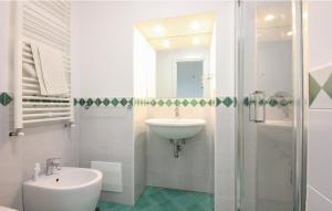 La salle de bains blanche est pourvue d'un lavabo et d'une douche. dans l'établissement Casa Gabriella, à Vietri