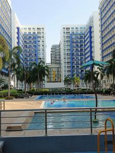 a swimming pool in a city with tall buildings at Sea Residences MOA -PaulJade Place in Manila