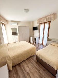 Habitación de hotel con 2 camas y TV en Hotel Riviera, en Porto San Giorgio