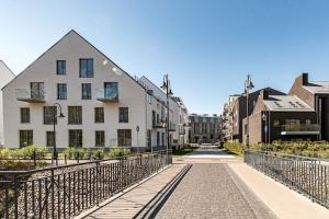 einen Gehweg in einer Stadt mit einem weißen Gebäude in der Unterkunft Spacious luxury apt w/river view/terrace Paupys in Vilnius