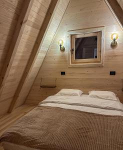 a bed in a wooden room with a window at Portes du Soleil - Zabljak in Žabljak