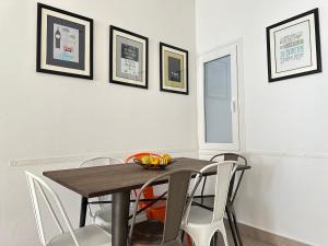 a dining room with a wooden table and white chairs at Agi Joan Badosa in Roses