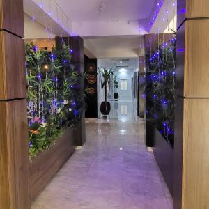 a hallway with a flower wall with blue lights at melbrookeparkhotel in Lagos