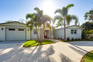 a house with palm trees in front of a driveway at Pet-Friendly Retreat in Stuart with Saltwater Pool! in Stuart