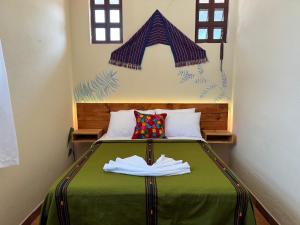パナハチェルにあるHotel Panajachel Oasisの小さなベッドルーム(緑の毛布付きのベッド付)