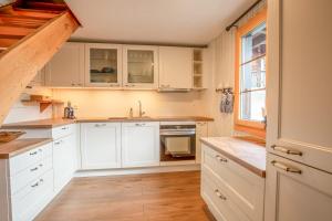 a kitchen with white cabinets and a window at Reste Fidèle Duplex in Fiesch