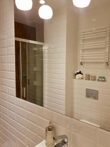 uma casa de banho com um lavatório e um espelho em Apartamenty Kielce- Apartament Komfort przy Baseny Tropikalne, Kadzielnia, parking, faktura em Kielce