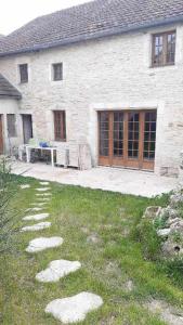 Casa de piedra con patio y mesa en chambres d'hôtes rue Pasteur en Is-sur-Tille