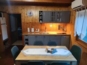 a kitchen with a wooden table and blue chairs at Chata Bobo in Stožok +49 photos