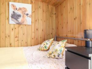 a bedroom with a bed with a picture of a cow on the wall at Maquessa Shepherd's Hut in Dumfries