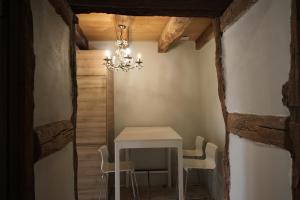 a table and chairs in a room with a chandelier at gite de la Tour Maria in Saint-Beauzeil