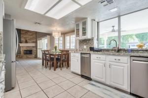 a kitchen with white cabinets and a dining room with a table at Luxury Vegas Home with 5BR, Casita, Hot Tub, and Pool in Las Vegas