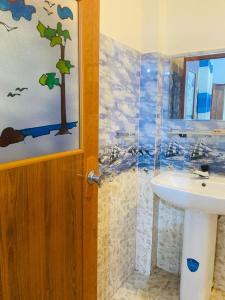 uma casa de banho com um lavatório e um chuveiro em Hotel Randiya em Nallathanniya