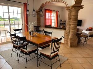 a dining room with a wooden table and chairs at Casa Alves - Villa with private heated swimming pool in Olhos de Água