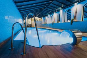 an indoor swimming pool with blue walls and metal rails at MS Aguamarina Costa del Sol in Torremolinos